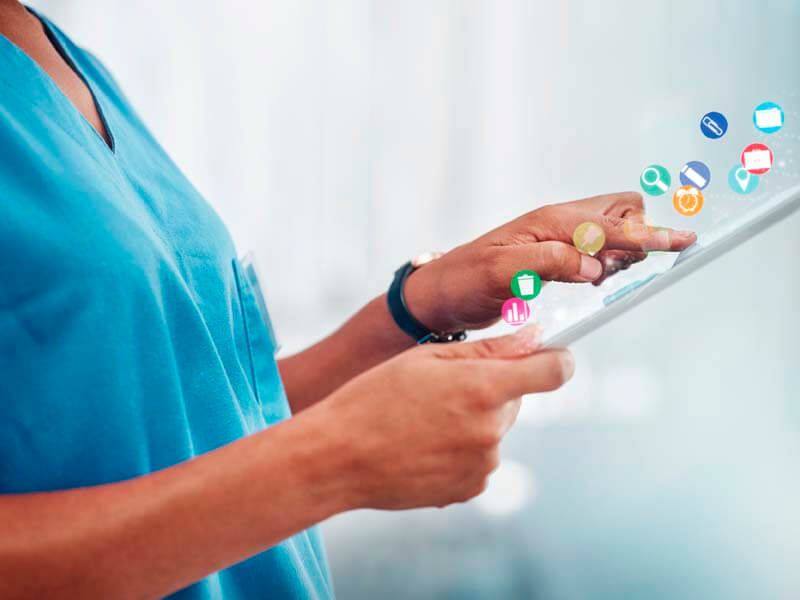 Profissional de saúde interagindo com aplicativos em tablet